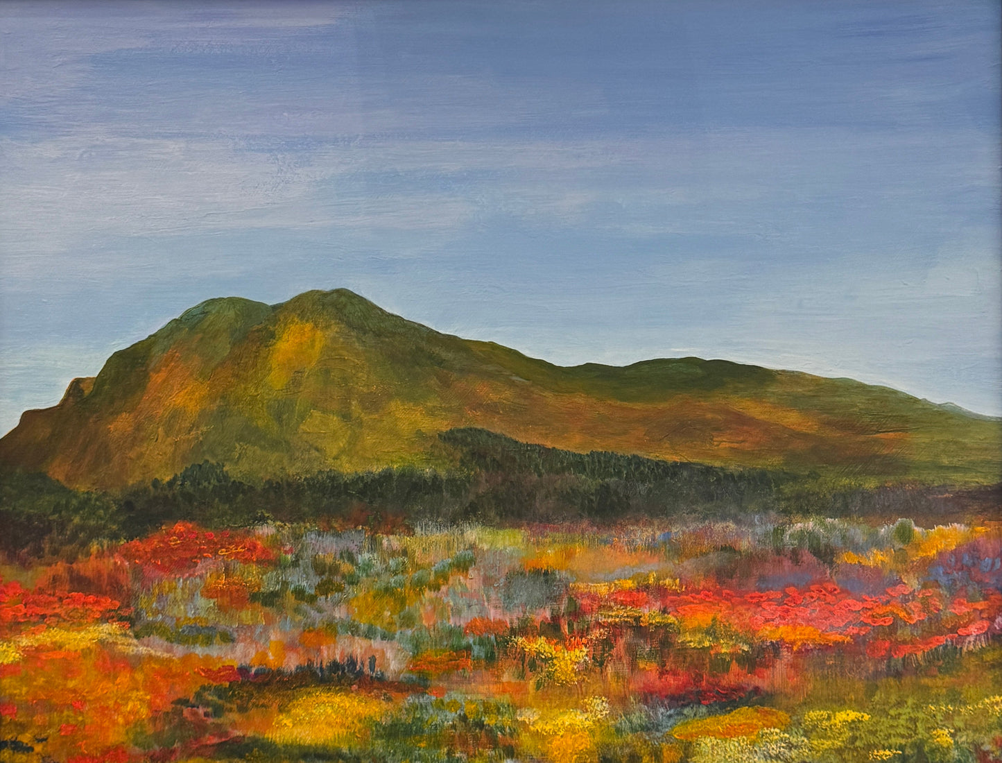Framed painting of a mountain landscape with colorful fields.