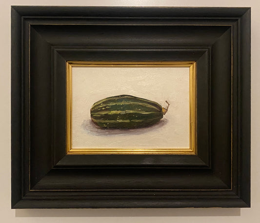Framed still life painting of a zucchini or gourd on a beige background