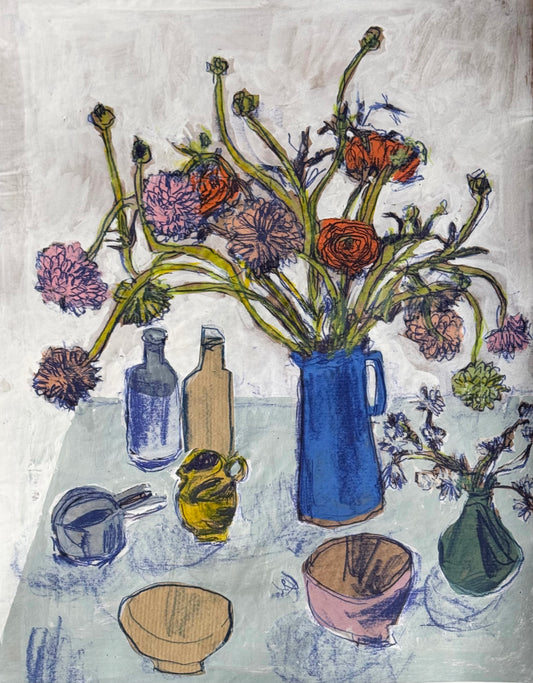 Still life with flowers in a blue vase and various objects on a textured surface