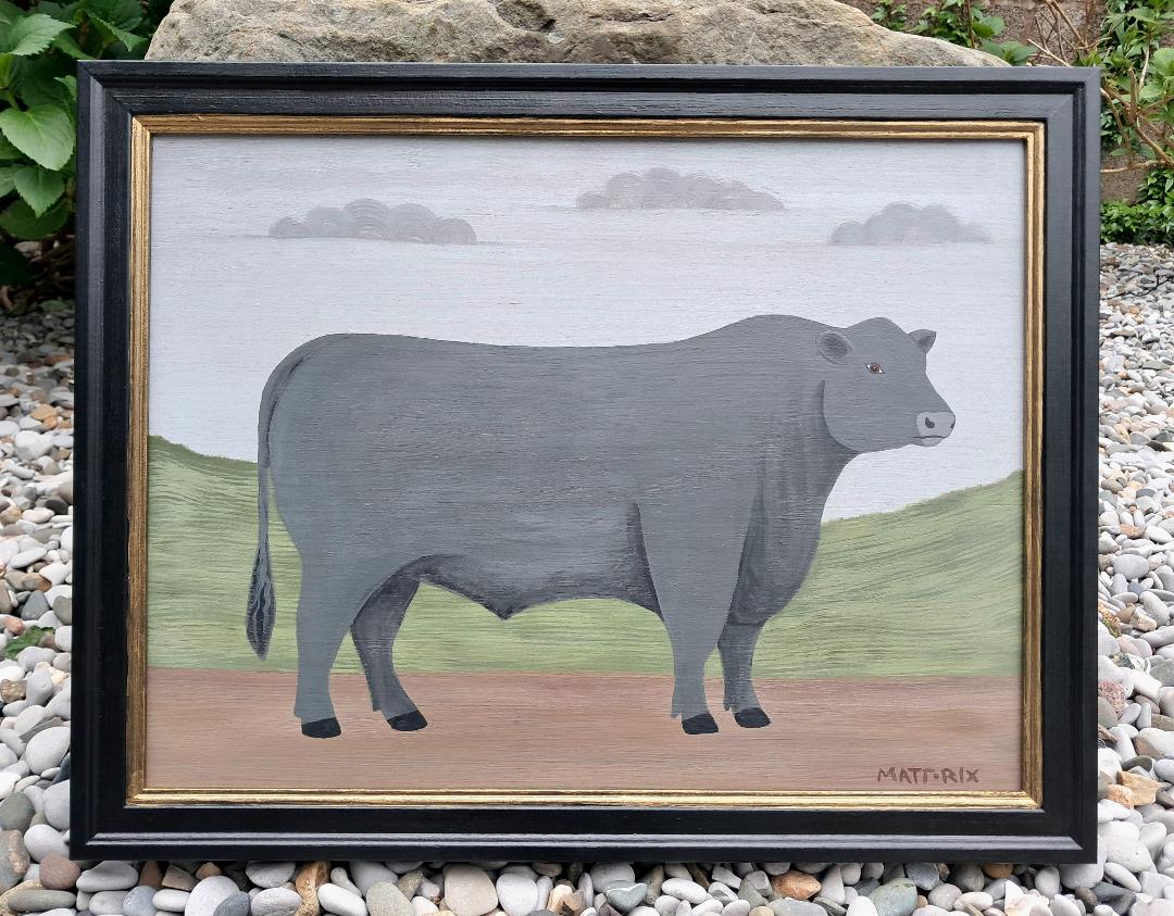 Framed artwork of a bull with a green hill background and blue sk with clouds.