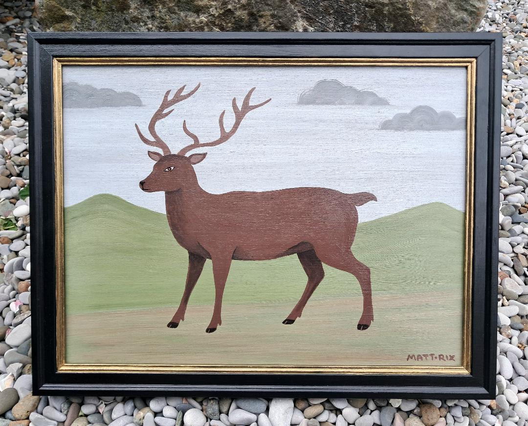 Framed artwork of an Stag on a green background with a blue sky.