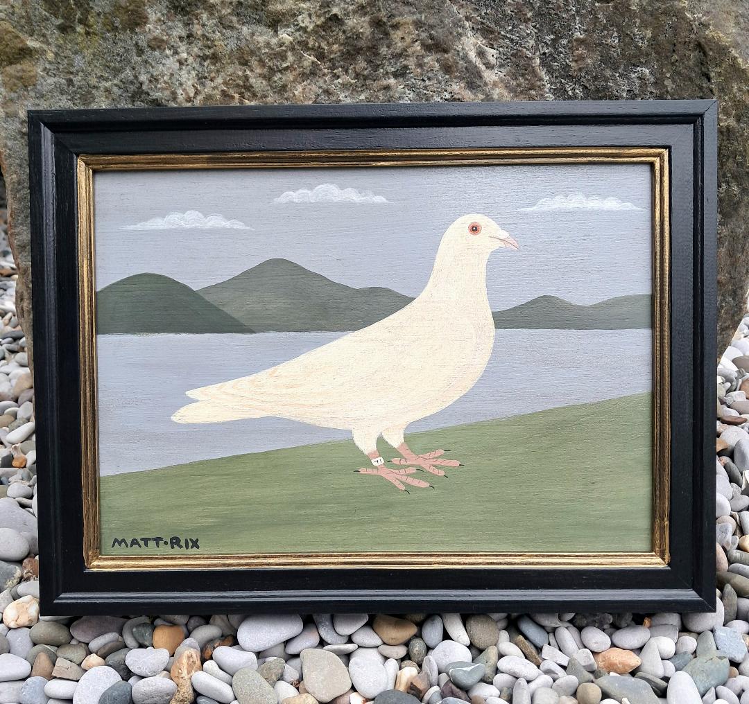 Framed artwork of a white pigeon on a landscape with mountains and water.