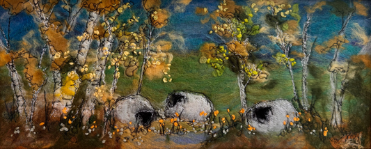 A framed landscape painting depicting birch trees with yellow and green foliage, white stones, and a blue sky, housed in a white frame with a gold inner border.