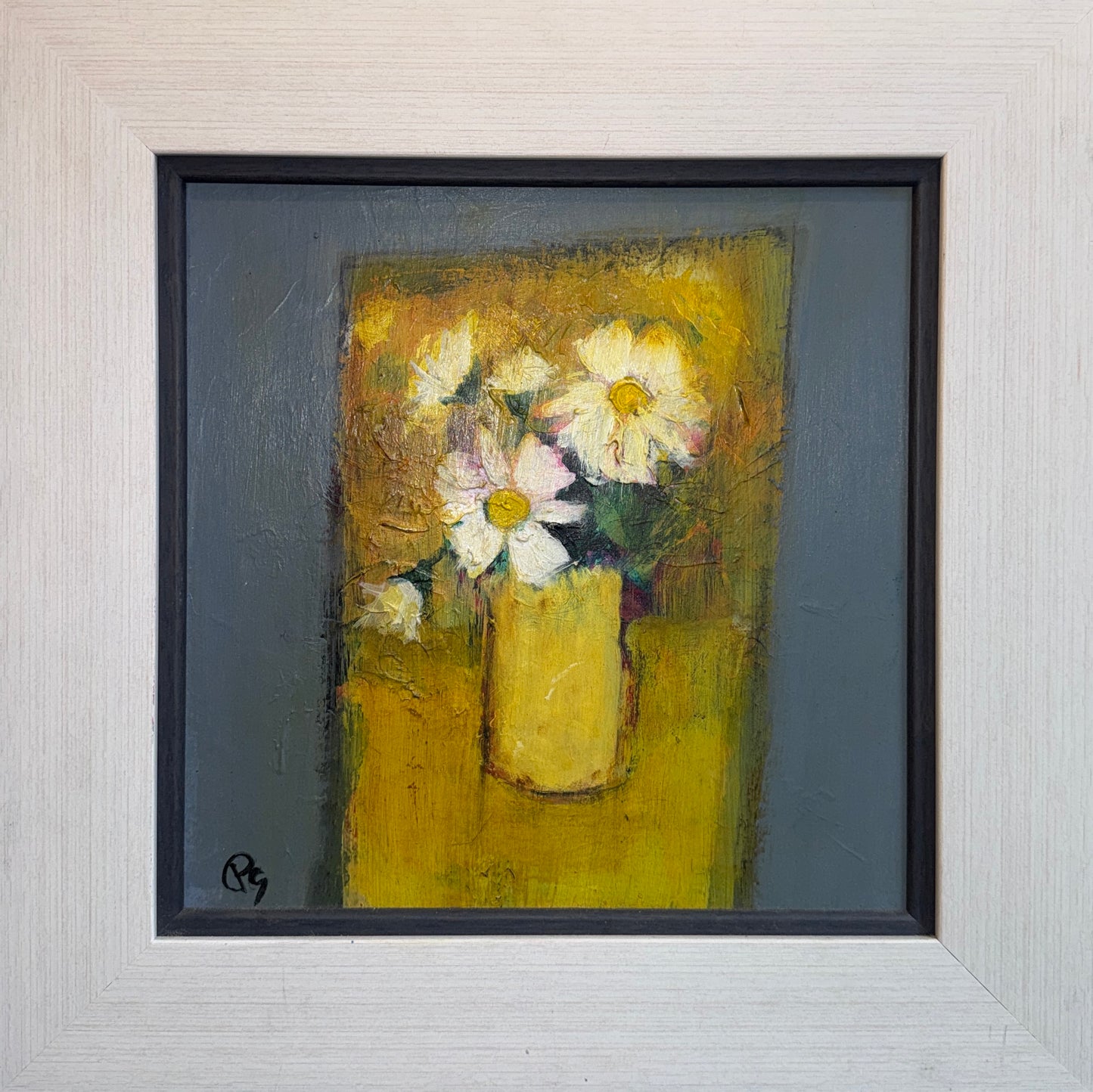 Framed painting of flowers in a yellow vase on a textured wall.