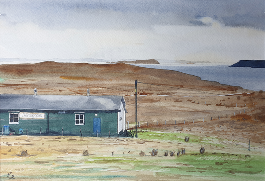 Small building with a blue door in a coastal landscape with hills and water.